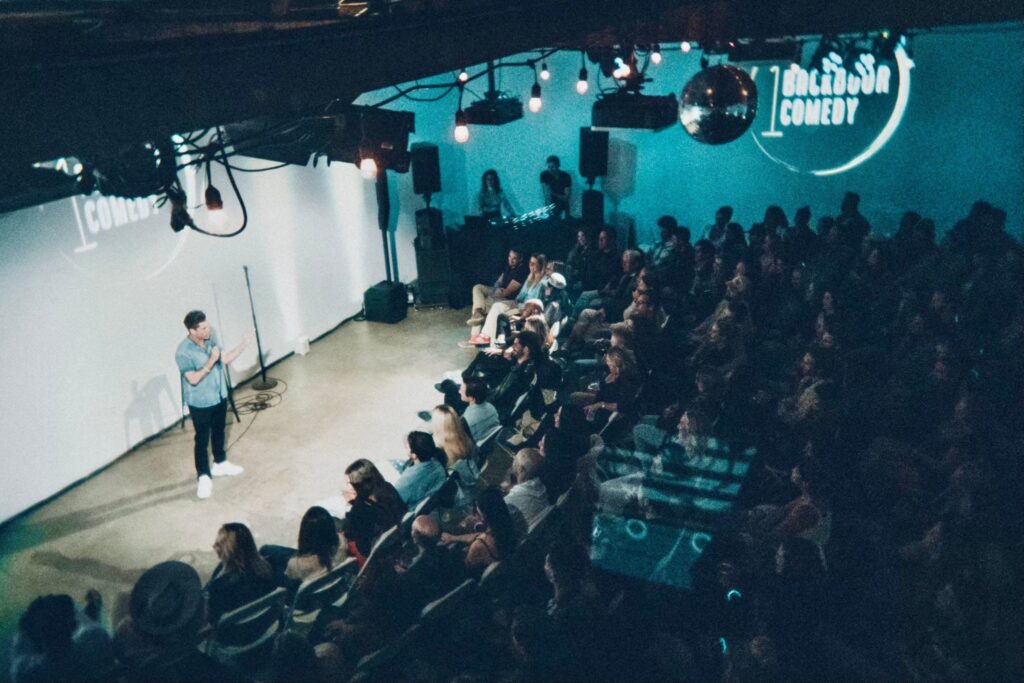 Crowd watching a comedian perform at a live comedy show