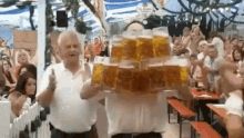 Oktoberfest server carrying a dozen full beer steins through a crowded beer hall