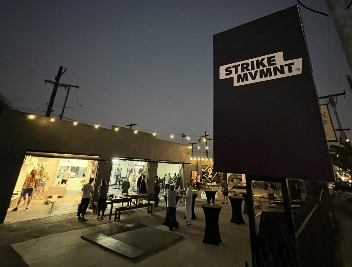 STRIKE MVMNT Pocket Shop lit up at night on the DEUCE Gym campus in Venice Beach